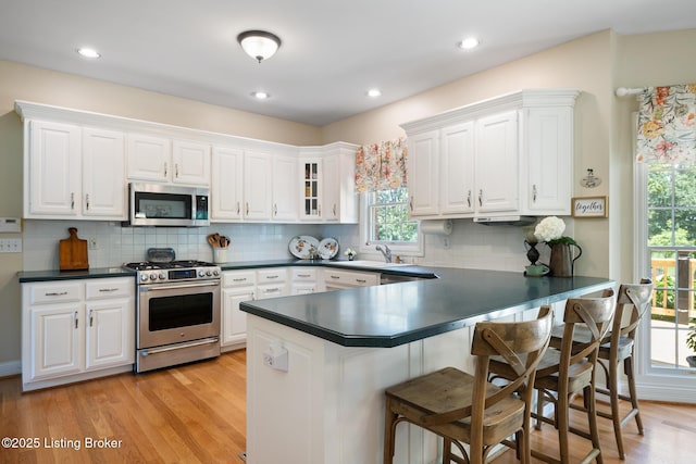 11731 Paramont Way, Prospect, KY 40059 - kitchen featuring appliances with stainless steel finishes, plenty of natural light, dark countertops, white cabinetry, and recessed lighting