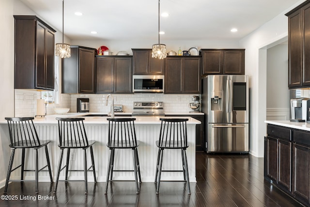 18007 Ellerslie Dr, Louisville, KY 40245 - kitchen featuring stainless steel appliances, dark brown cabinets, a peninsula, dark wood finished floors, and tasteful backsplash