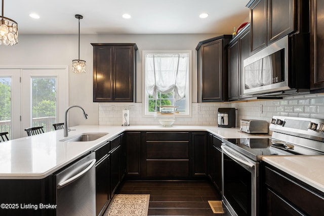 18007 Ellerslie Dr, Louisville, KY 40245 - kitchen with stainless steel appliances, a peninsula, light countertops, dark wood-style flooring, and recessed lighting