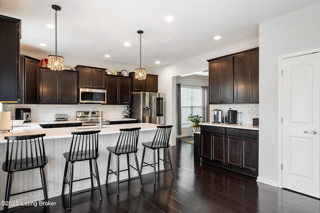 18007 Ellerslie Dr, Louisville, KY 40245 - kitchen with stainless steel appliances, dark brown cabinets, decorative backsplash, a peninsula, and recessed lighting