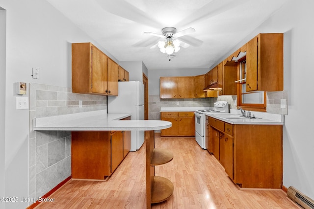 85 Joseph Ave, Cecilia, KY 42724 - kitchen featuring white appliances, a baseboard radiator, light countertops, and brown cabinetry