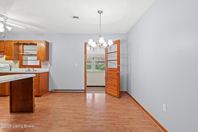 85 Joseph Ave, Cecilia, KY 42724 - kitchen featuring brown cabinets, light countertops, light wood-style flooring, a chandelier, and a ceiling fan