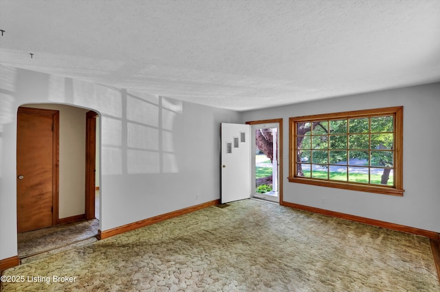 3010 Meade Ave, Louisville, KY 40217 - carpeted empty room with a textured ceiling and arched walkways