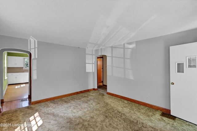3010 Meade Ave, Louisville, KY 40217 - empty room with arched walkways and carpet flooring