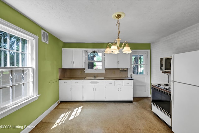 3010 Meade Ave, Louisville, KY 40217 - kitchen featuring white appliances, a chandelier, white cabinets, a textured ceiling, and hanging light fixtures
