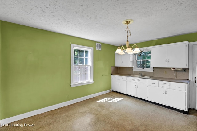 3010 Meade Ave, Louisville, KY 40217 - kitchen with a chandelier, white cabinets, dark countertops, hanging light fixtures, and a textured ceiling