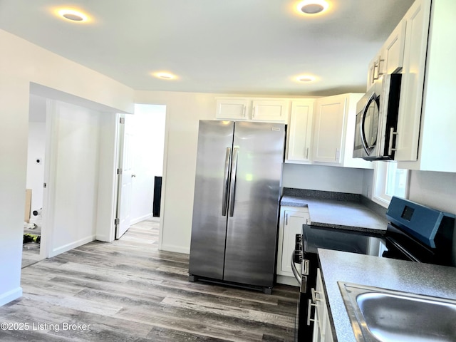6910 Sylvania 4 Rd, Louisville, KY 40258 - kitchen featuring appliances with stainless steel finishes, light wood-style floors, and white cabinets