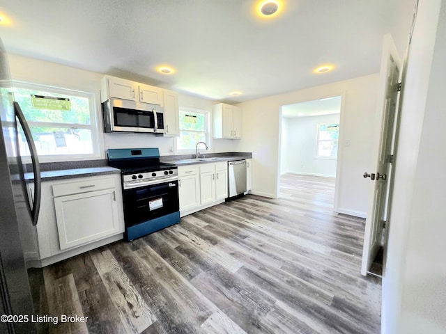 6910 Sylvania 4 Rd, Louisville, KY 40258 - kitchen featuring appliances with stainless steel finishes, wood finished floors, dark countertops, white cabinetry, and recessed lighting