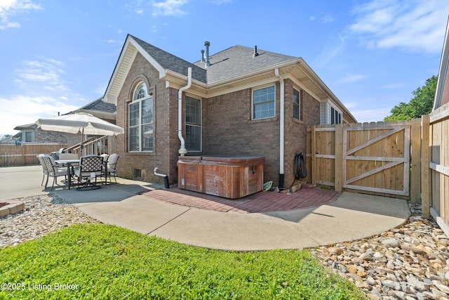 5613 Grandel Blvd, Louisville, KY 40258 - back of house with a hot tub, a patio area, a gate, and brick siding