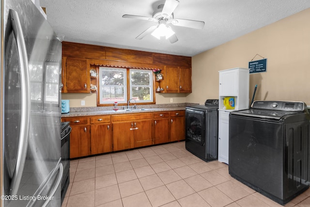 1255 Holy Cross Rd, Loretto, KY 40037 - kitchen featuring freestanding refrigerator, brown cabinetry, black / electric stove, a ceiling fan, and washer and clothes dryer