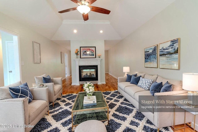 9829 Galene Dr, Jeffersontown, KY 40299 - living area featuring vaulted ceiling, a ceiling fan, wood finished floors, ornamental molding, and a glass covered fireplace