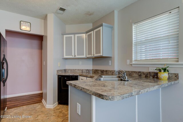 6813 Casey Pl, Louisville, KY 40229 - kitchen with black dishwasher, a peninsula, and a textured ceiling
