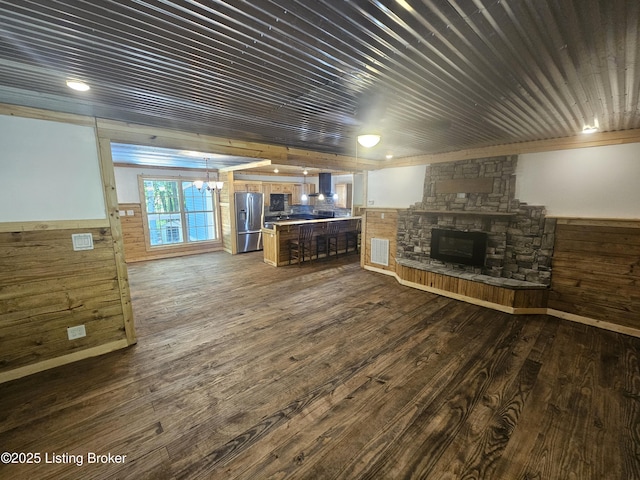 409 Woodhaven Ln, Leitchfield, KY 42754 - living room with wood walls, wainscoting, dark wood-style floors, a fireplace, and a chandelier