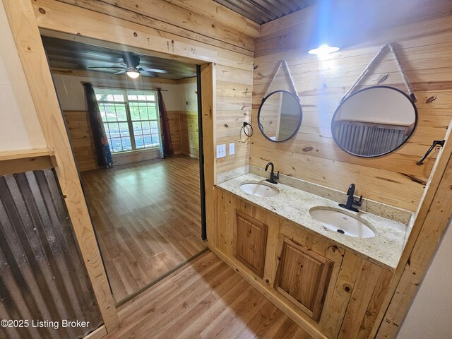 409 Woodhaven Ln, Leitchfield, KY 42754 - bathroom with wooden walls, wood finished floors, double vanity, and ceiling fan