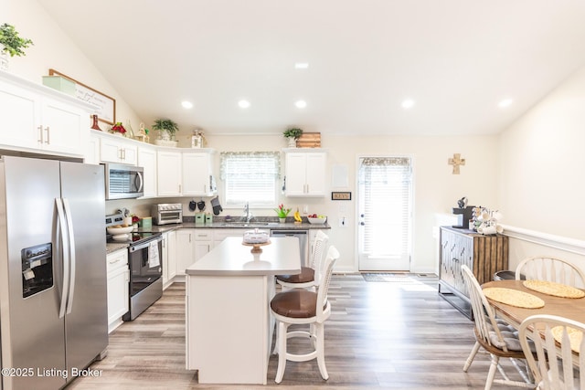 414 Turnberry Ct, Vine Grove, KY 40175 - kitchen with stainless steel appliances, white cabinetry, a kitchen island, a kitchen breakfast bar, and light wood-style floors