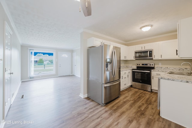 5105 Kilmer Blvd, Louisville, KY 40213 - kitchen with appliances with stainless steel finishes, wood finished floors, light stone counters, crown molding, and white cabinets