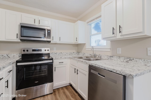 5105 Kilmer Blvd, Louisville, KY 40213 - kitchen featuring appliances with stainless steel finishes, crown molding, white cabinets, light wood-style flooring, and light stone counters