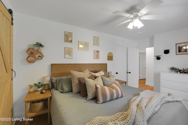 312 Norbourne Blvd, Louisville, KY 40207 - bedroom with a barn door, ceiling fan, and wood finished floors