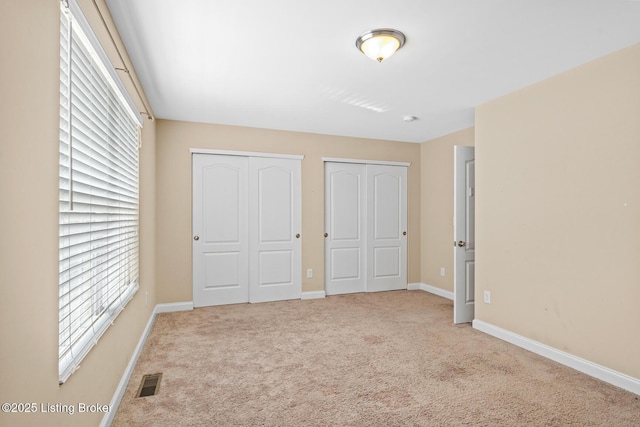 9006 Big Boulder Dr, Louisville, KY 40291 - unfurnished bedroom with two closets, carpet flooring, and multiple windows