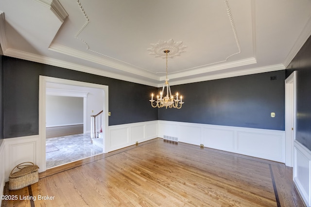 7202 Doe Crest Ct, Prospect, KY 40059 - unfurnished dining area featuring a tray ceiling, a decorative wall, wainscoting, a chandelier, and wood finished floors