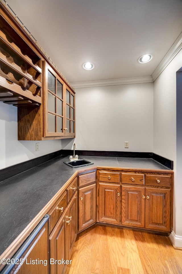 7202 Doe Crest Ct, Prospect, KY 40059 - kitchen with ornamental molding, brown cabinets, dark countertops, glass insert cabinets, and light wood-type flooring