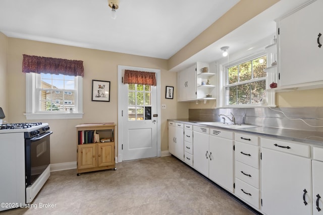 2628 Landor Ave, Louisville, KY 40205 - kitchen with white gas range oven, stainless steel counters, open shelves, and plenty of natural light