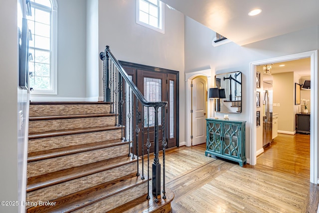 17503 Polo Run Ln, Louisville, KY 40245 - foyer featuring wood finished floors, stairs, arched walkways, and a high ceiling