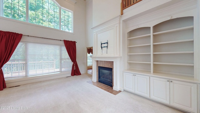 5407 Merribrook Ln, Prospect, KY 40059 - unfurnished living room with light colored carpet, a tiled fireplace, built in shelves, and a towering ceiling