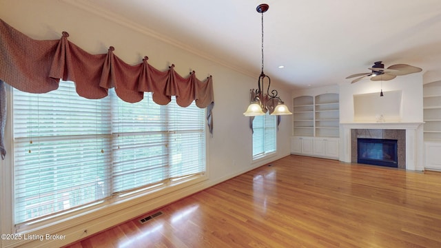 5407 Merribrook Ln, Prospect, KY 40059 - unfurnished living room with light wood-style floors, ceiling fan, a tile fireplace, ornamental molding, and built in features
