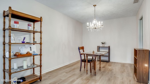 3030 Breckenridge Ln Apt 201, Louisville, KY 40220 - dining area featuring wood finished floors, a chandelier, and a textured ceiling