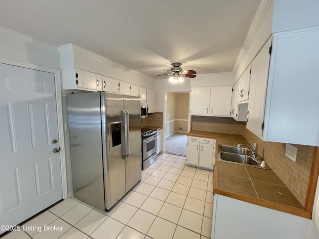 2804 Creekside Dr, Louisville, KY 40241 - kitchen featuring appliances with stainless steel finishes, light tile patterned floors, white cabinets, a ceiling fan, and decorative backsplash