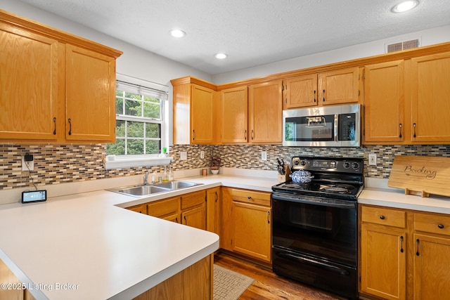 1403 Cadence Ct, Louisville, KY 40222 - kitchen featuring black electric range, stainless steel microwave, light countertops, a peninsula, and a textured ceiling