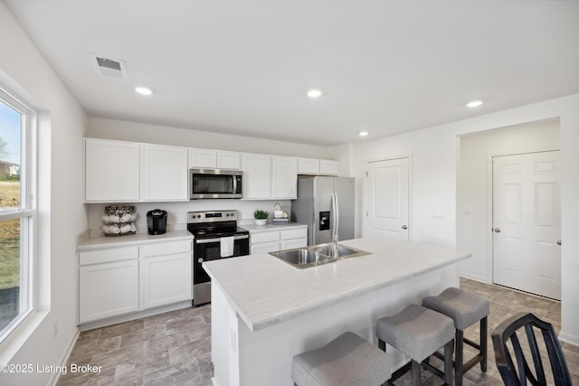 1520 Robin Rd, Shelbyville, KY 40065 - kitchen featuring stainless steel appliances, a kitchen breakfast bar, stone finish floors, white cabinets, and recessed lighting