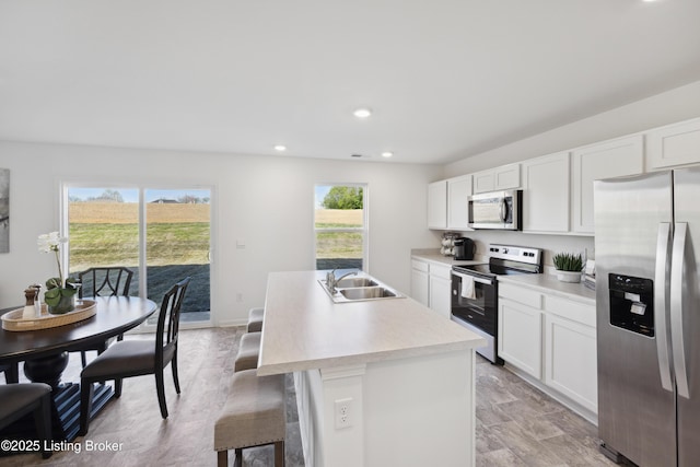 1520 Robin Rd, Shelbyville, KY 40065 - kitchen with appliances with stainless steel finishes, a center island with sink, light countertops, white cabinetry, and recessed lighting