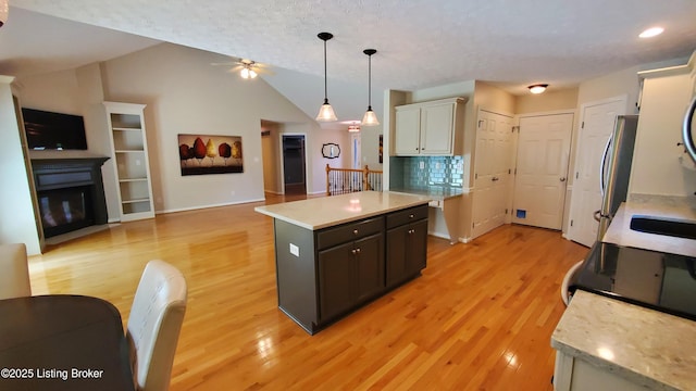 4318 Juniper Forest Pl, Louisville, KY 40245 - kitchen featuring light countertops, ceiling fan, light wood finished floors, lofted ceiling, and a kitchen island