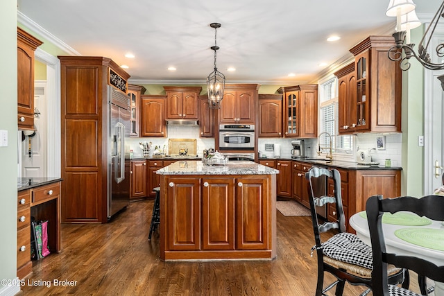 15018 Forest Oaks Dr, Louisville, KY 40245 - kitchen featuring a center island, dark wood-style floors, under cabinet range hood, glass insert cabinets, and crown molding