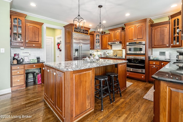 15018 Forest Oaks Dr, Louisville, KY 40245 - kitchen featuring stainless steel appliances, decorative backsplash, a center island, under cabinet range hood, and ornamental molding