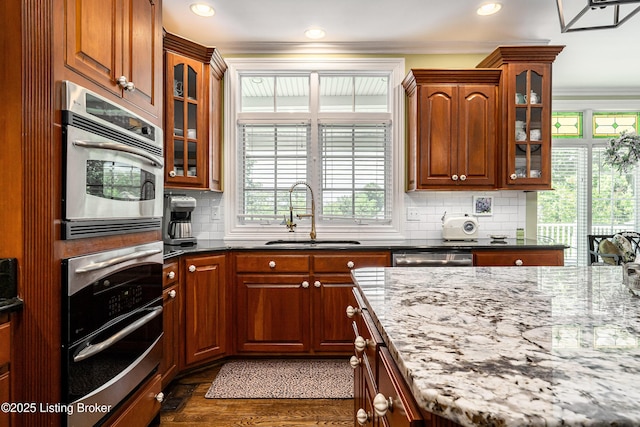 15018 Forest Oaks Dr, Louisville, KY 40245 - kitchen with crown molding, backsplash, dark stone counters, stainless steel appliances, and glass insert cabinets