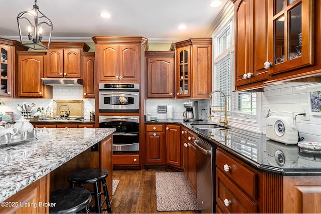 15018 Forest Oaks Dr, Louisville, KY 40245 - kitchen featuring stainless steel appliances, under cabinet range hood, dark stone countertops, tasteful backsplash, and brown cabinetry