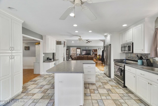 236 Running Creek Dr, Shepherdsville, KY 40165 - kitchen with appliances with stainless steel finishes, ceiling fan, a center island, open floor plan, and stone tile floors