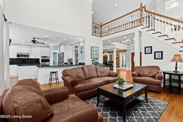3111 Ridgemoor Ct, Prospect, KY 40059 - living room with a chandelier, light wood-style floors, a high ceiling, ornate columns, and ceiling fan