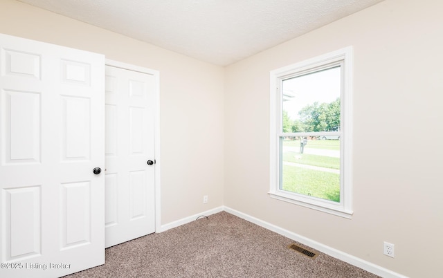 517 Oak Leaf Dr, La Grange, KY 40031 - unfurnished bedroom featuring multiple windows, carpet flooring, and a textured ceiling