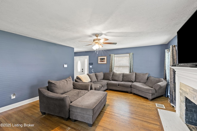 908 Chestnut Ave, Frankfort, KY 40601 - living room featuring a fireplace with flush hearth, wood finished floors, a ceiling fan, and a textured ceiling