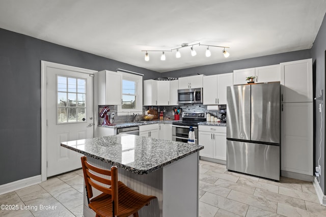 908 Chestnut Ave, Frankfort, KY 40601 - kitchen with appliances with stainless steel finishes, stone counters, decorative backsplash, a breakfast bar, and white cabinets