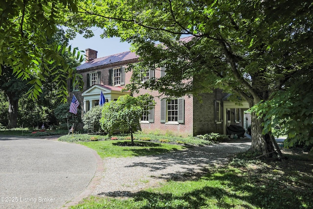 2406 Tucker Station Rd, Louisville, KY 40299 - colonial inspired home featuring brick siding, a standing seam roof, a metal roof, and a chimney