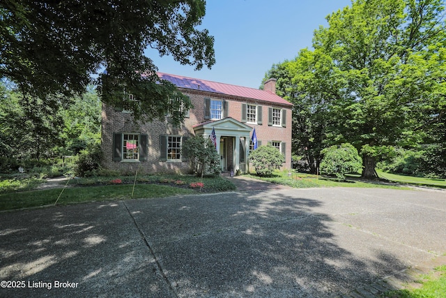 2406 Tucker Station Rd, Louisville, KY 40299 - colonial house with a chimney, brick siding, and a metal roof