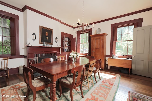 2406 Tucker Station Rd, Louisville, KY 40299 - dining room featuring wood-type flooring, a chandelier, a fireplace, and crown molding