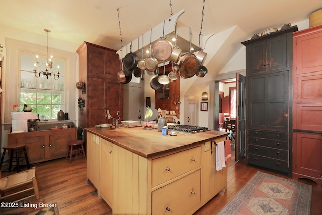 2406 Tucker Station Rd, Louisville, KY 40299 - kitchen with butcher block countertops, hardwood / wood-style floors, a chandelier, stainless steel gas stovetop, and pendant lighting