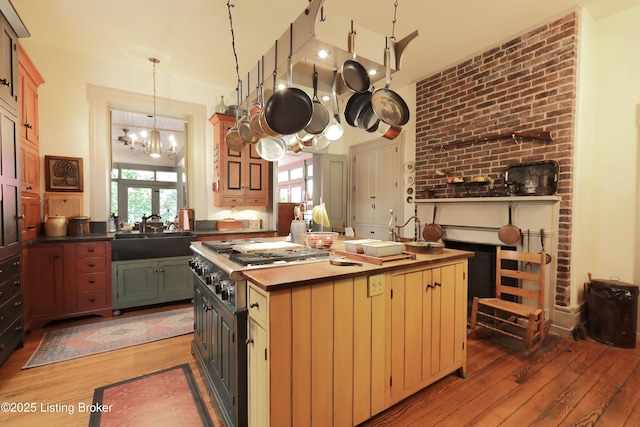 2406 Tucker Station Rd, Louisville, KY 40299 - kitchen with light wood-type flooring, a chandelier, dark countertops, stainless steel gas stovetop, and a center island