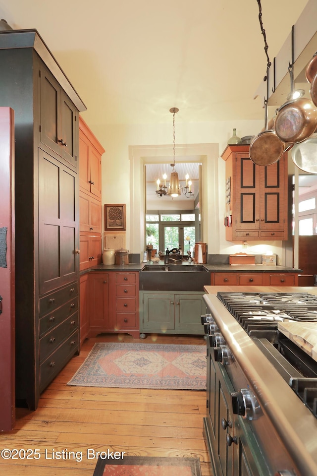 2406 Tucker Station Rd, Louisville, KY 40299 - kitchen with light wood finished floors, a chandelier, hanging light fixtures, and dark countertops